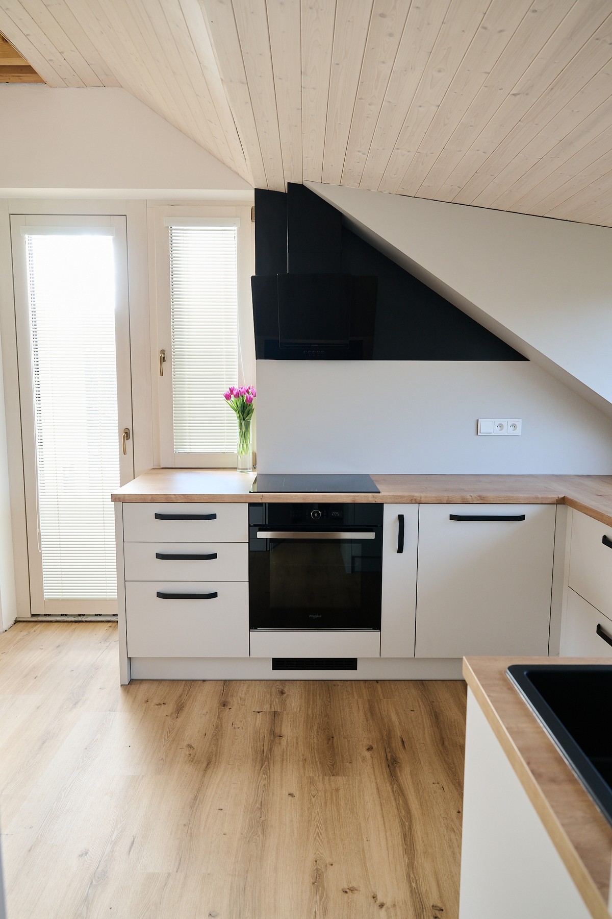 Bílá kuchyň v podkroví - detail vysokých skříněk